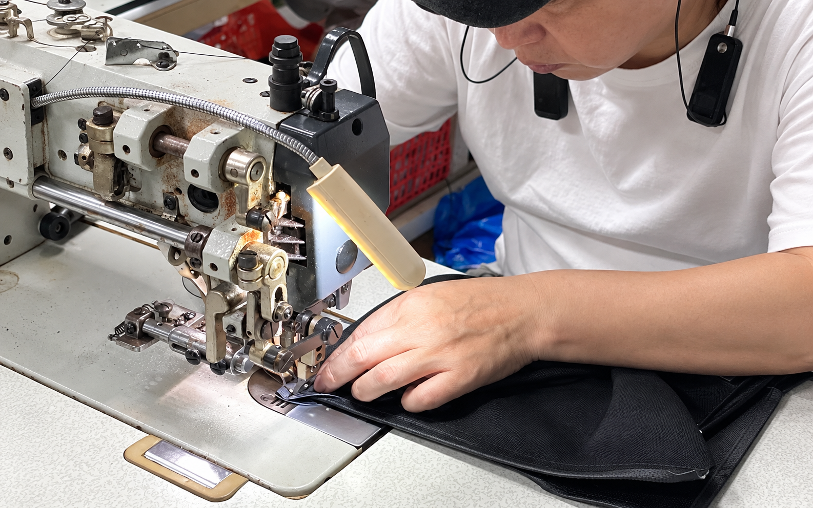 Operator sewing a black bag panel at Pengnan Bags