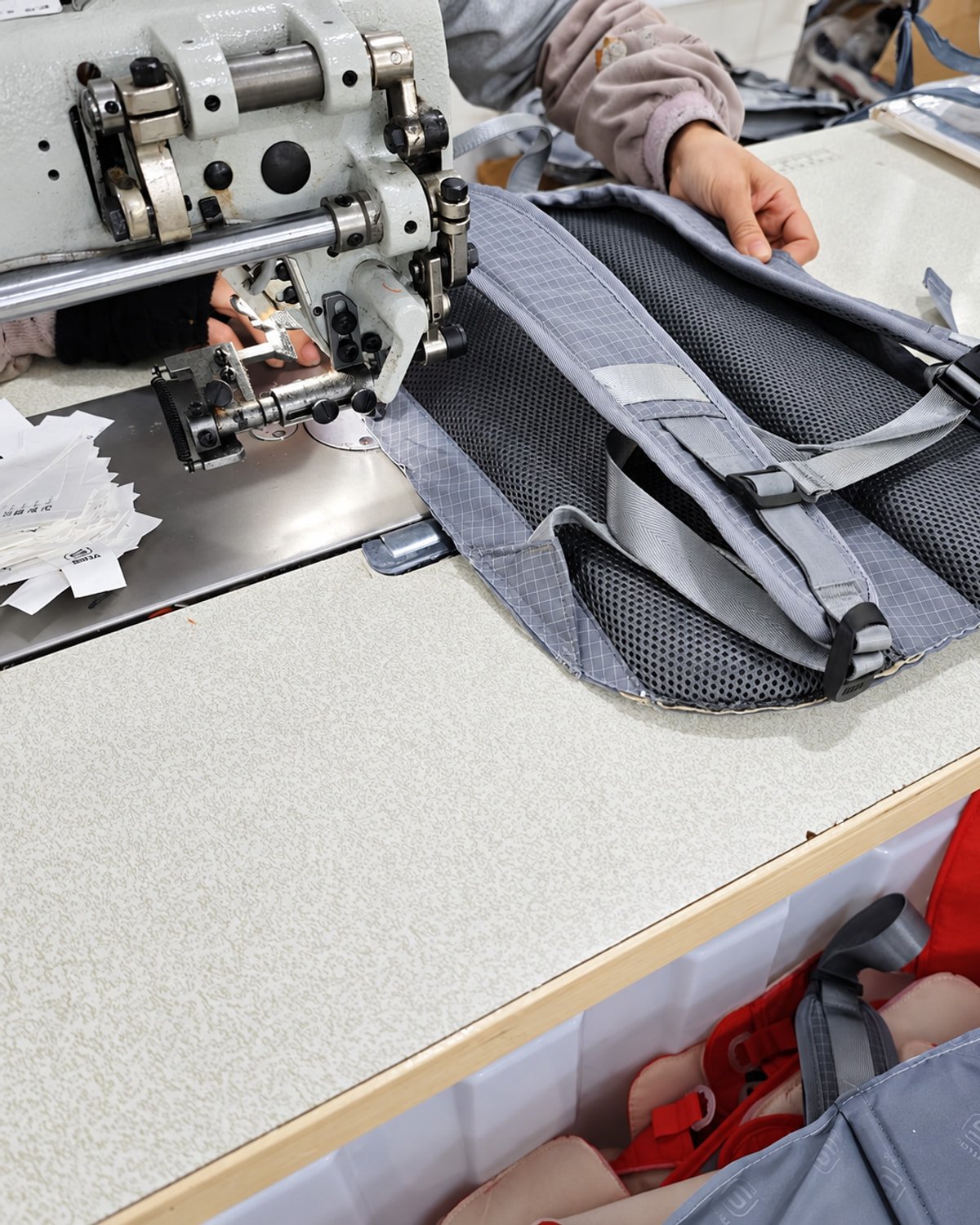 Close-up of backpack shoulder strap stitching during bag production